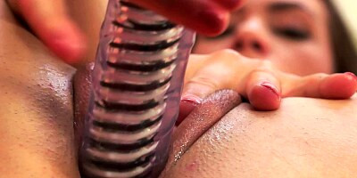 A hot chick pushes a dildo into her pussy and smiles at us