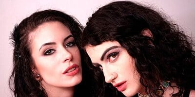 Cute-looking girls Anna De Ville and Lydia Black are sucking a huge dildo