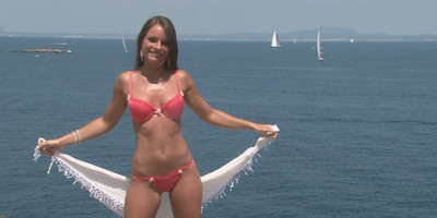 Gorgeous brunette removes her bikini on the beach